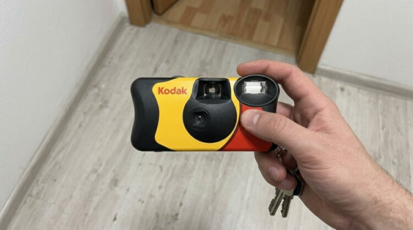 Плёночная камера Kodak в руке со связкой ключей. Фото.
