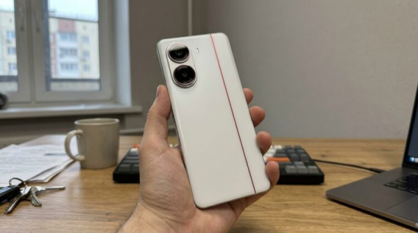 Смартфон Redmi Turbo 4 в руке, вид сзади