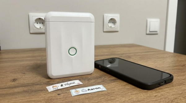 Принтер этикеток Niimbot D110 рядом со смартфоном