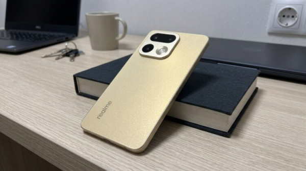 Смартфон Realme золотистого цвета на книге