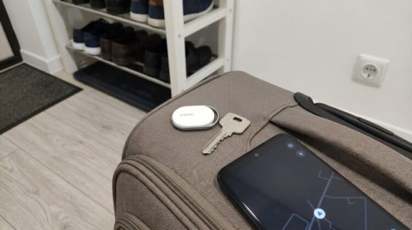 Брелок Xiaomi Tag на связке ключей рядом с чемоданом
