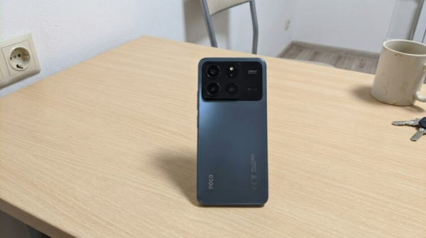 Смартфон Poco X8 Pro на столе задней панелью вверх