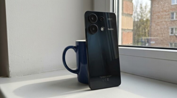 Смартфон Redmi на подоконнике, задняя панель с камерами
