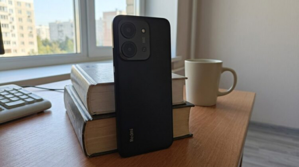 Смартфон Redmi, опёртый на стопку книг
